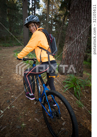 Female biker with mountain bike in countryside Female biker with mountain bike in countryside 32105611