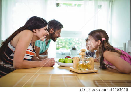 Parents and kids looking face to face and smiling Parents and kids looking face to face and smiling 32105696
