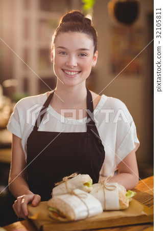 Portrait of smiling waitress holding a tray with sandwiches Portrait of smiling waitress holding a tray with sandwiches 32105811