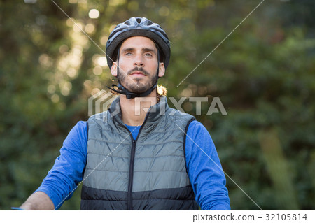 Thoughtful male biker in forest 32105814