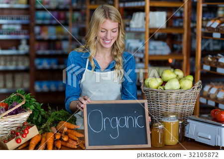 Female staff holding organic sign board Female staff holding organic sign board 32105872