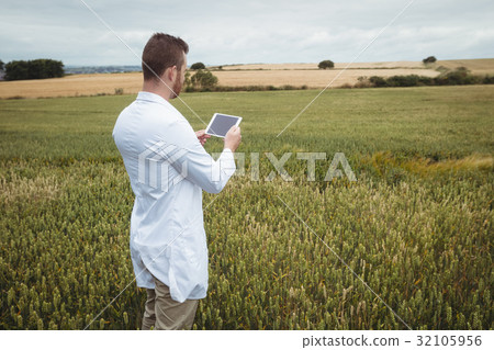 Agronomist using digital tablet in the field 32105956
