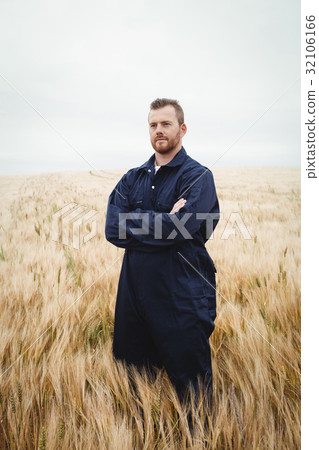 Farmer standing with arms crossed in the field 32106166