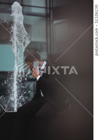 Businessman using laptop while talking on phone 32106230