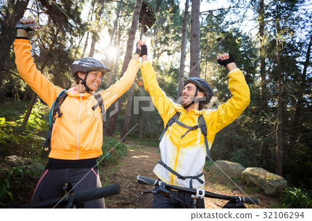 Biker couple with mountain bike in countryside Biker couple with mountain bike in countryside 32106294