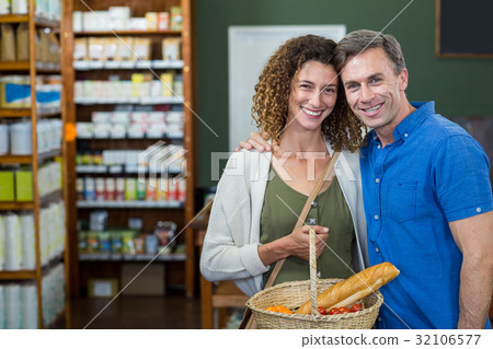 Portrait of happy couple standing with a basket Portrait of happy couple standing with a basket 32106577