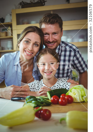 Portrait of happy family leaning on kitchen worktop Portrait of happy family leaning on kitchen worktop 32106579