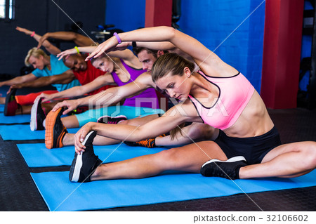 People doing stretching exercise in gym People doing stretching exercise in gym 32106602