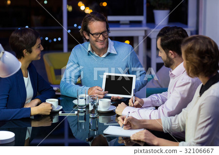Businessman discussing work on digital tablet with colleagues 32106667