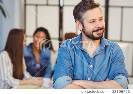 Businessman looking away against female coworkers 32106706