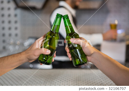 Two men toasting a bottle of beer 32106707
