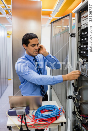Technician talking on mobile phone 32106727