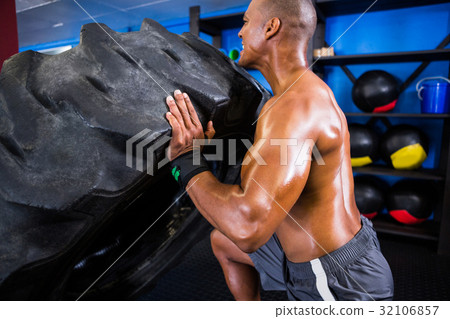 Shirtless athlete pushing tire Shirtless athlete pushing tire 32106857