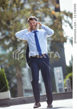 Portrait of handsome businessman talking on mobile phone 32106890