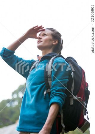 Female hiker shielding her eyes 32106903