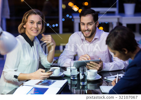 Businessman and businesswoman smiling in office Businessman and businesswoman smiling in office 32107067