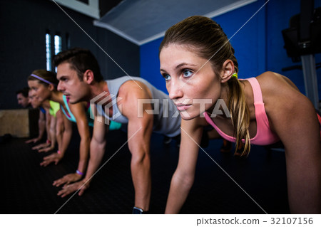 Athletes doing push-ups in gym Athletes doing push-ups in gym 32107156