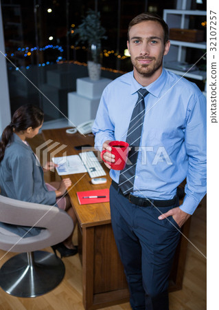 Business executive standing with a cup of coffee 32107257