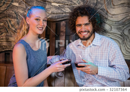 Couple toasting glass of wine in bar 32107364