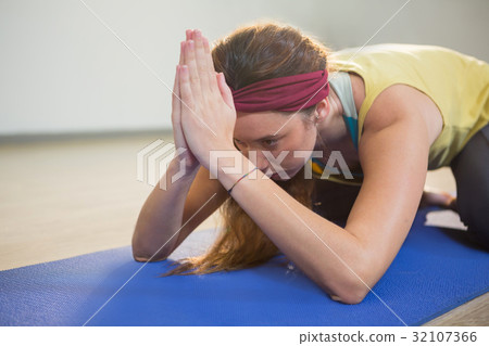 Woman performing yoga on exercise mat Woman performing yoga on exercise mat 32107366