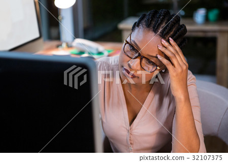 Businesswoman working on computer at her desk Businesswoman working on computer at her desk 32107375