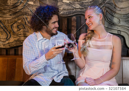 Couple toasting glass of wine in bar Couple toasting glass of wine in bar 32107384