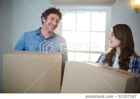 Couple holding cardboard boxes Couple holding cardboard boxes 32107387