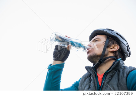 Male mountain biker drinking water Male mountain biker drinking water 32107399