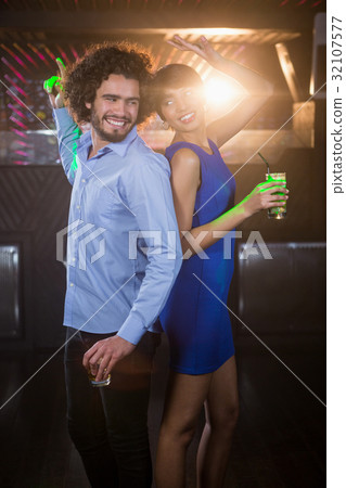 Cute couple dancing together on dance floor while having drink 32107577