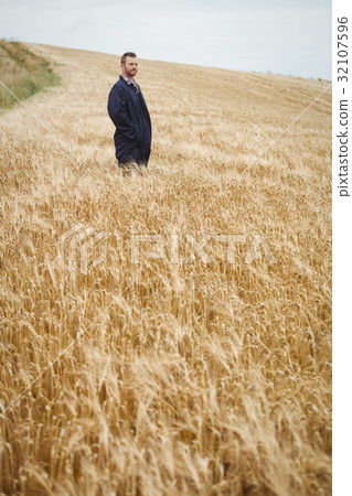 Farmer standing in the field 32107596
