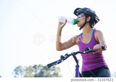 Female cyclist drinking water Female cyclist drinking water 32107621