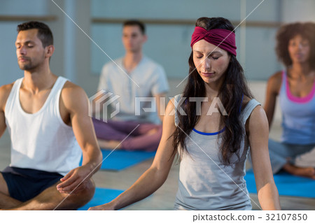 Group of people performing yoga 32107850