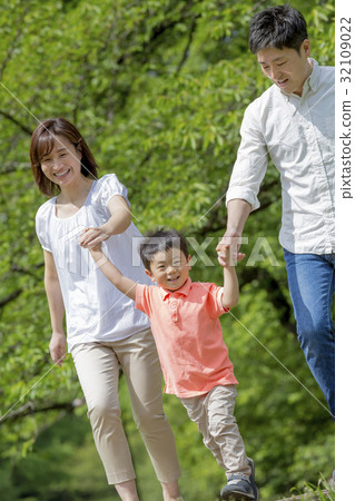 Three people walking in a park of fresh green 32109022