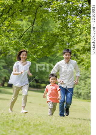 Three families running in a fresh green park 32109032