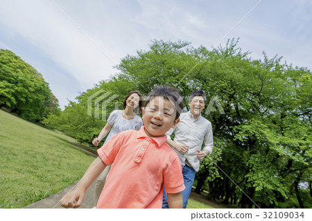 Three people walking in a park of fresh green 32109034