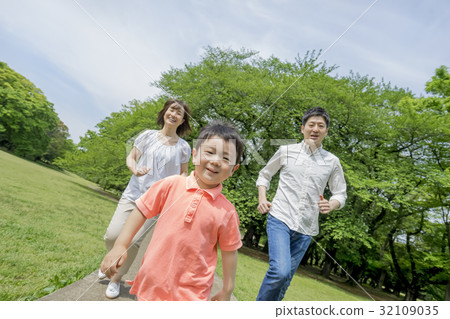 Three people walking in a park of fresh green 32109035