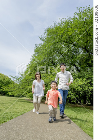Three people walking in a park of fresh green 32109036