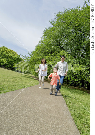 Three people walking in a park of fresh green 32109037