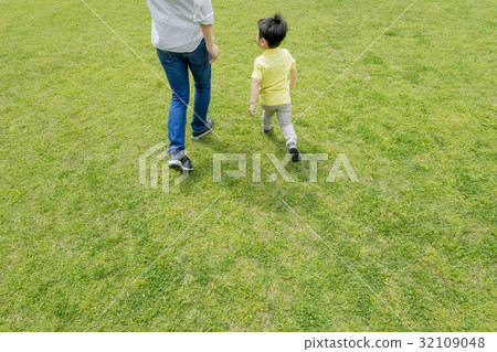 Father and son behind behind playing in a fresh green park 32109048