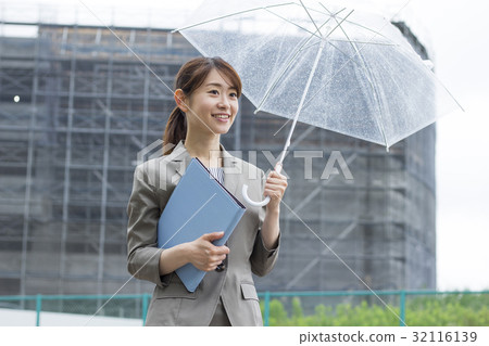 Business woman pointing an umbrella 32116139