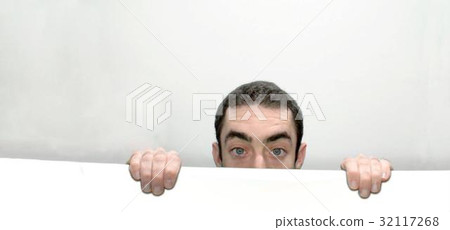 Man peeking behind a white wall Man peeking behind a white wall 32117268