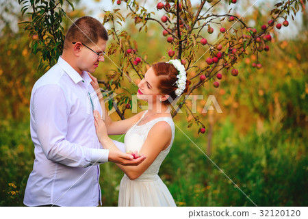 The bride and groom are kissing in the apple  32120120