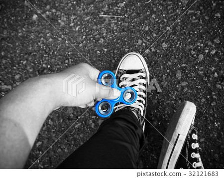 Selfie of fidget spinner on hand with shoes 32121683