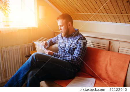 Young handsome man sitting on the couch Young handsome man sitting on the couch 32122940