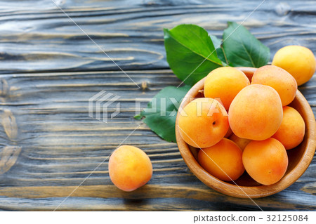 Delicious ripe apricots in a wooden bowl. Delicious ripe apricots in a wooden bowl. 32125084