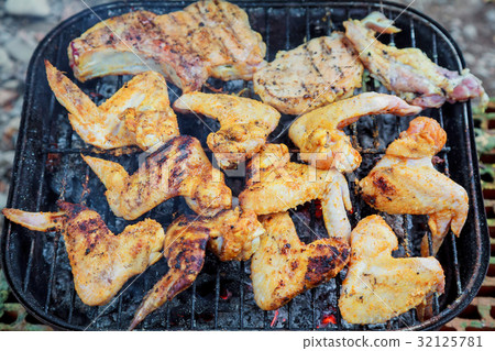Grilling chicken wings on barbecue grill. Grilling chicken wings on barbecue grill. 32125781