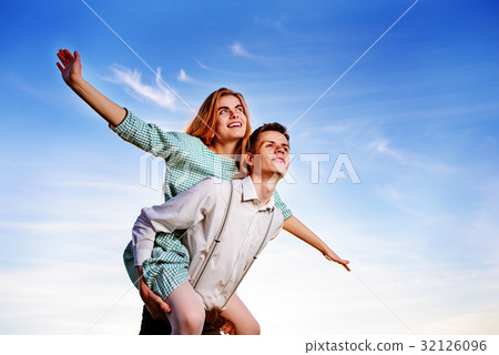 Young guy piggybacking cheerful girlfriend like Young guy piggybacking cheerful girlfriend like 32126096