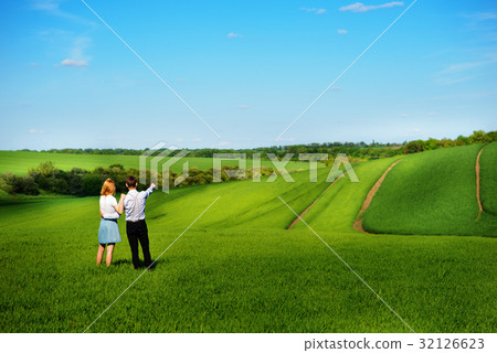 couple standing in the field, the girl  32126623
