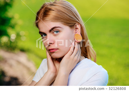 beautiful woman with wooden tunnels in her ears 32126808