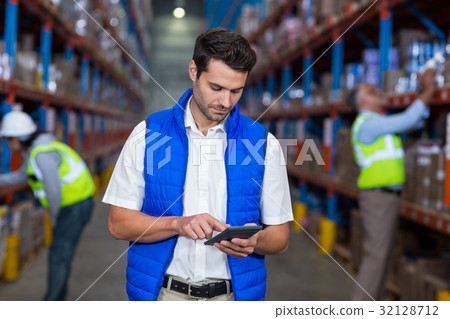 Warehouse worker using calculator 32128712